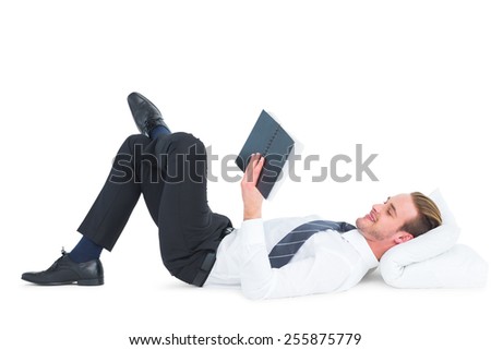 Relaxed businessman lying and reading book on white background