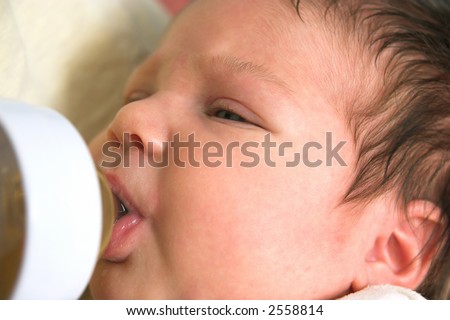 new born baby drinking from nursing bottle
