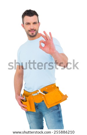 Smiling handyman gesturing okay on white background