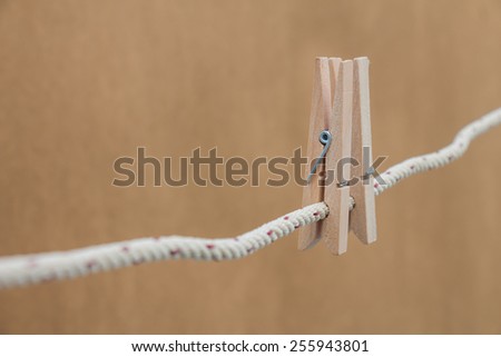 wooden clothespin hanging on brown background, depth of field