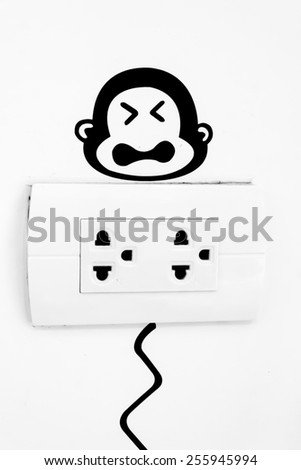 Monkey picture above power plug  warning for energy savings.
Monkey picture above power plug.