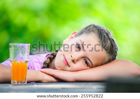 Yang preteen and cute girl pictured with glass of juice.