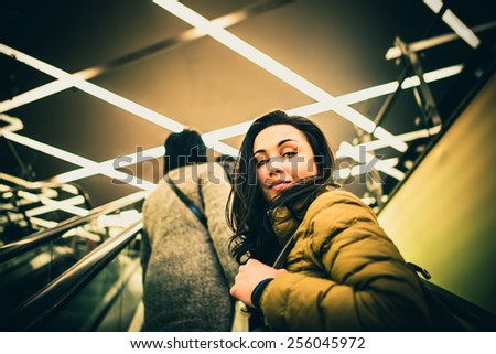 Long hair girl on the escalator in the shopping center