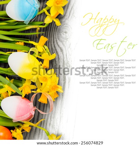 Easter eggs with daffodil blooms on wooden board with white space for text