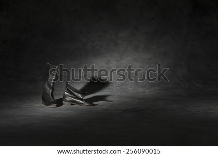  old and dirty military boots in dark studio background
