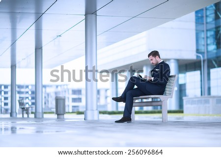 young business man at office building reading newspaper.
 Royalty-Free Stock Photo #256096864