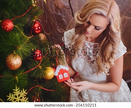 Beautiful young woman near a Christmas tree with gifts