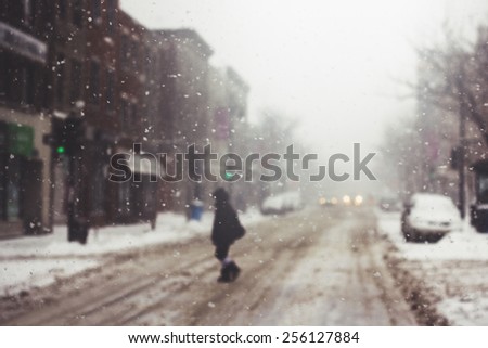 Person crossing the street during a snow storm.