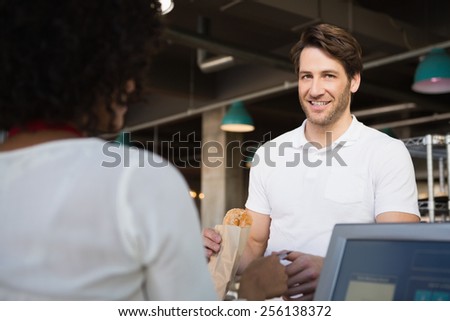 Customer paying her bread to waiter at the bakery