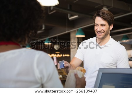 Customer paying by credit card her bread at the bakery