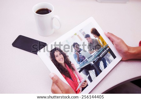 Composite image of smiling designer using tablet