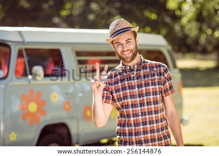 Handsome hipster smiling at camera on a summers day