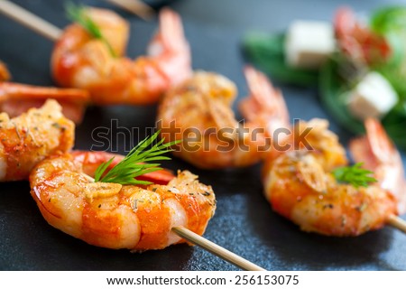 Extreme close up detail of appetizing queen prawn brochette. Royalty-Free Stock Photo #256153075