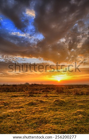 Colorful spring sunset with Sun rays coloring the clouds