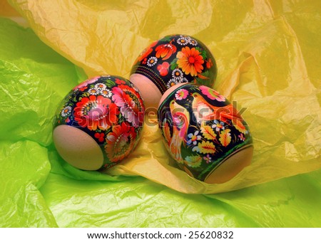 three Easter eggs on a background to the yellow and green paper