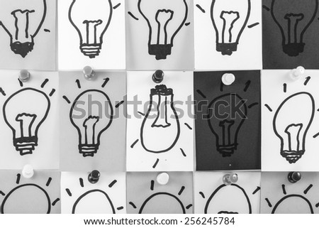 Draw bulb on paper note black and white color background. 