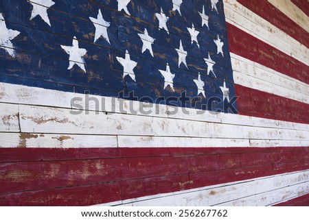 A painting of an American flag on a wood plank wall