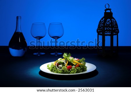 Salad plate with blue background and glasses in silhouette
