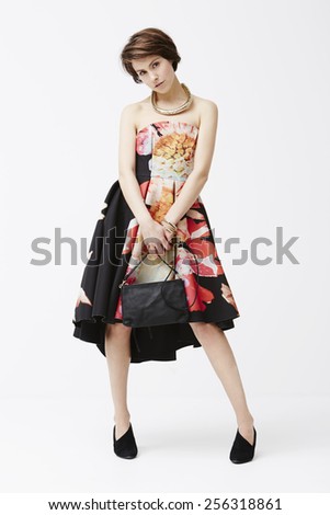 Confident woman posing in glamorous dress, studio