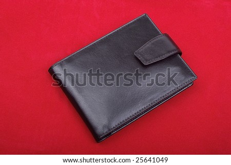 High quality black leather wallet isolated on red background. Studio shot.