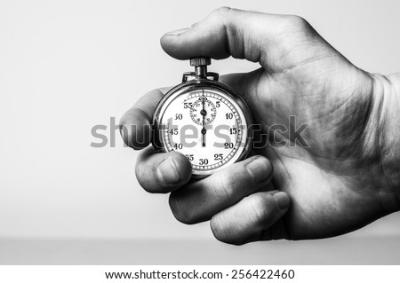 Hand holding retro stopwatch in black & white Royalty-Free Stock Photo #256422460