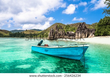 Old fishing boat on a Tropical beach at Curieuse island Seychelles. Horizontal shot Royalty-Free Stock Photo #256426234