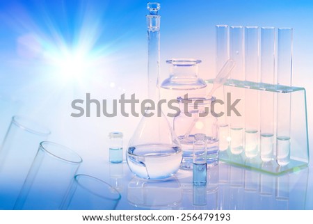 Scientific background with chemical glass, flask and tubes. This is a background element with most of frame out of focus. Focus is on small glass vial and round flask. Space for your text or caption.
