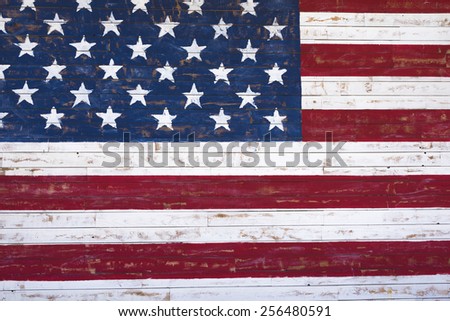 A painting of an American flag on a wood plank wall