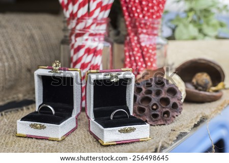 wedding rings in boxes with vintage style accessories in the background