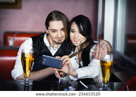 Friends taking picture of themselves with smartphone, couple in love