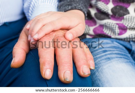 Photo of a child hand on elderly man hand