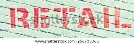 Retail written in orange ink on a brick wall