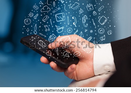 Hand holding smartphone with hand drawn media icons and symbols concept