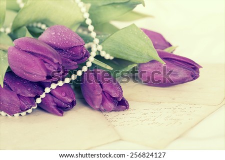 Old love letters and purple tulips. Retro style toned picture