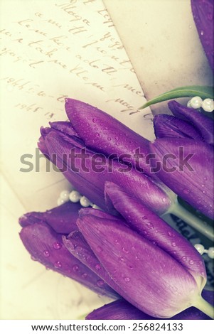 Old love letters and purple tulips. Retro style toned picture