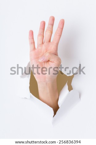 Four finger breaking through paper wall