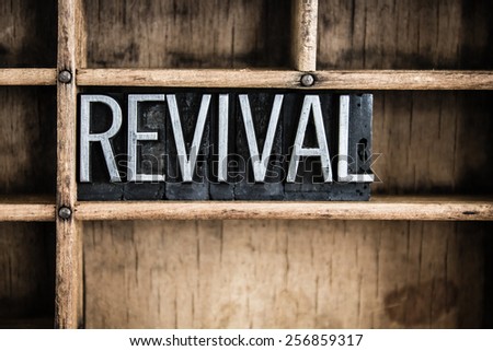 The word "REVIVAL" written in vintage metal letterpress type in a wooden drawer with dividers. Royalty-Free Stock Photo #256859317