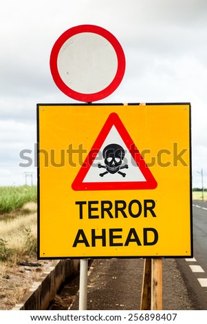 social concept with a yellow traffic sign and a red warning triangle with a skull and the message Terror ahead beside the road