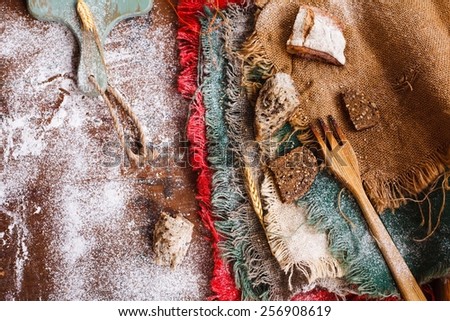 Healthy and authentic food concept. Still life with different slices whole, grain bread and 
burlap textured onto a vintage kitchen table. Top view. Rustic style.