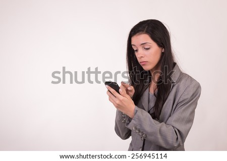 Young executive woman dressed in grey and with a cellular texting