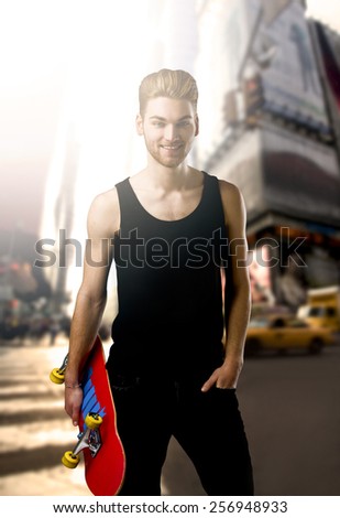 Studio portrait of a young man posing with a skateboard on street of New York