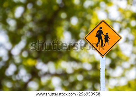 Yellow traffic sign on green blurred bokeh background