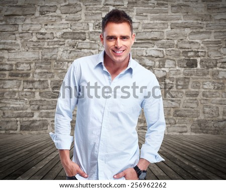 Handsome young man portrait over vintage wall background.