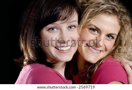 Two Pretty woman friends in pink hugging