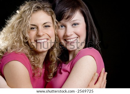 Two Pretty woman friends in pink hugging