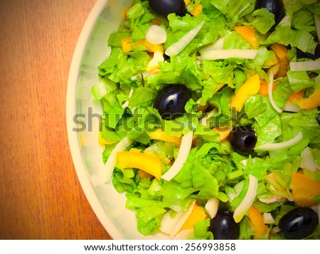 Assorted salad of green leaf lettuce with squid and black olives, close up. instagram image retro style