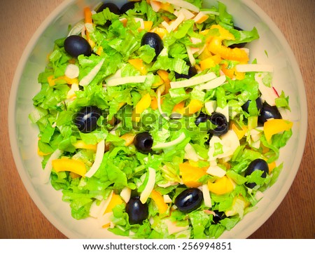 Assorted salad of green leaf lettuce with squid and black olives. instagram image retro style