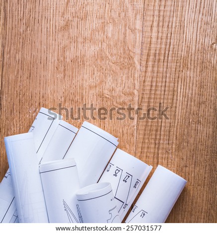 stack of white rolled up blueprints on wooden board with copyspace 