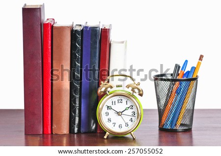 Time to learn. Books and alarm clock on the table