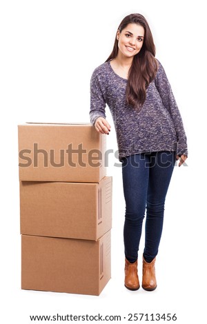 Full length portrait of a cute young woman standing next to a pile of boxes